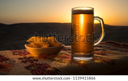 Close Up of A Glass of Beer with the snacks on Sunlight Background. Selective focus