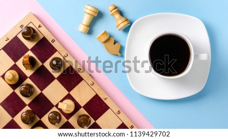 White cup with black coffee on a saucer and chessboard with figures. Pink and blue background. Flat lay concept. Pastel shades