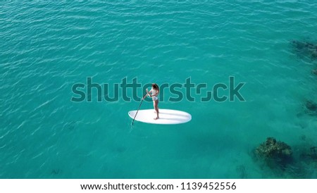  Aerial view. Young Woman on Paddle Board. SUP