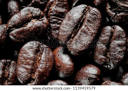 Close up coffee bean,coffee bean of the dark tone for background.Coffee of macro picture using for background and wallpaper or texture.coffee cup,black coffee,coffee brown,cup,wood,macro coffee.dark c