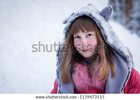 Winter portrait of beautiful girl in a hat with ears