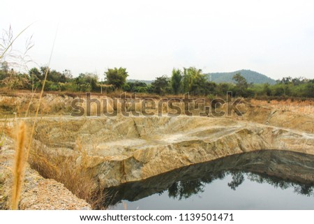 Abandoned soil quarry where water fills within the center of the quarry, Chiang Mai, Northern Thailand.