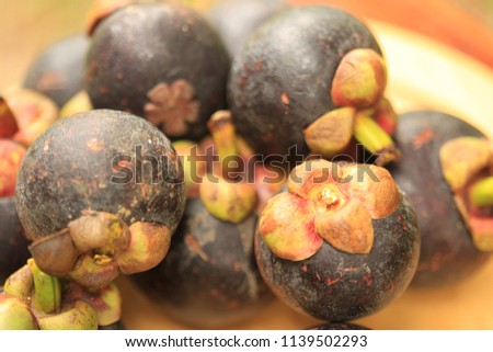 Mangosteen fruit on the ground. Peeled for white meat inside. In Thailand Mangosteen is a fruit that tastes sweet.