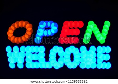Blurred light cutout black background , open and welcome Text