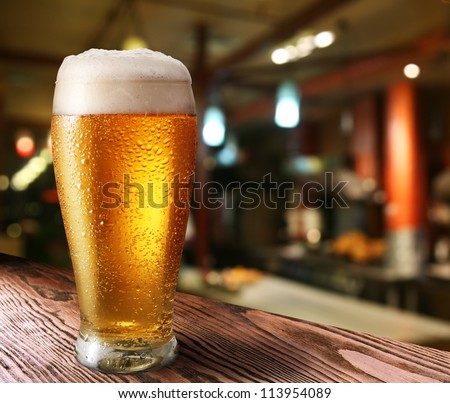 Glass of light beer on a dark pub. Royalty-Free Stock Photo #113954089