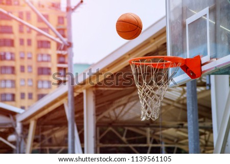 Action shot of basketball falls basketball hoop and net on park background