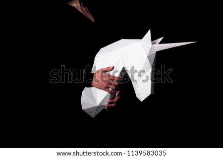 Hands hold white unicorn. Artwork. 3d model unicorn papercraft. Copy space