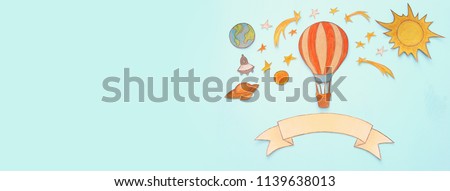 Banner of Hot air balloon, space elements shapes cut from paper and painted over wooden blue background