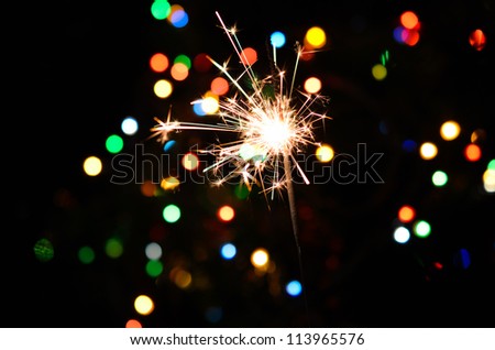 Christmas sparkler and background of colorful bokeh Royalty-Free Stock Photo #113965576