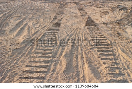 Tracks from tires and bulldozer tracks in a dusty earth Royalty-Free Stock Photo #1139684684