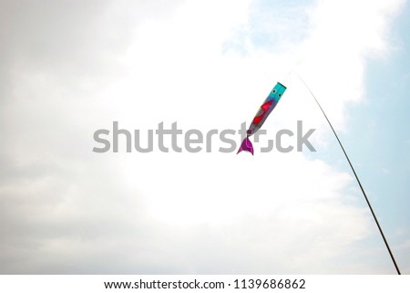 Japanese carp windsock flag on pole flying against sky 
