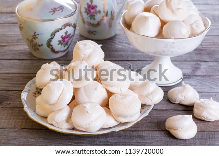 Small homemade white meringue cake on wooden table. Homemade Meringue.