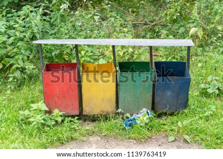 multi-colored garbage containers in the city park