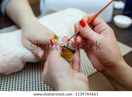 Nail technician makes nail extensions gel in the beauty salon. Professional care for hands.