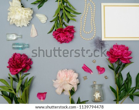 
White Blank Frame Mockup in frame made of pink peony flowers over gray paper with copy space. Top View. Flat Lay.