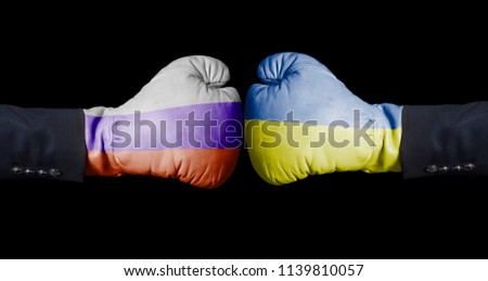 Boxing gloves with Russian and Ukrainian flag. Russia versus Ukraine concept on black Royalty-Free Stock Photo #1139810057