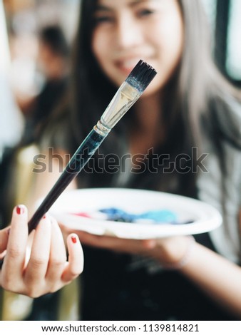Young Asian woman painting picture in class,creative woman design her artwork.