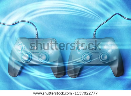 Video game controllers on dark background, color effect. Leisure and entertainment