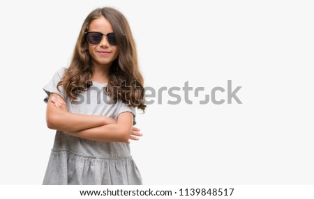 Brunette hispanic girl wearing sunglasses happy face smiling with crossed arms looking at the camera. Positive person.