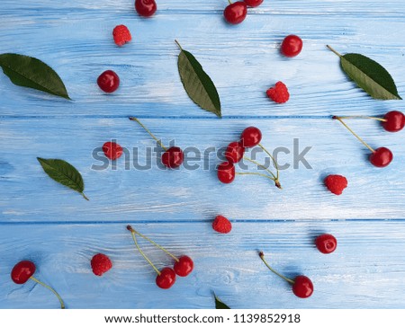 ripe cherry berry on a blue wooden background, pattern
