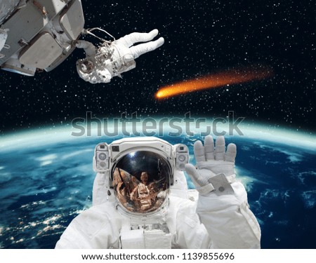 Astronaut waving in front. Comet on the background. The elements of this image furnished by NASA.
