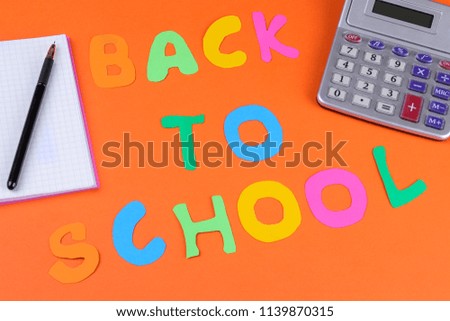 School supplies on a bright orange background with the inscription back to school