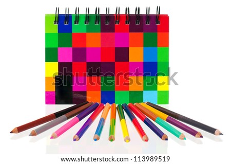School exercise-book with colour pencils on white background