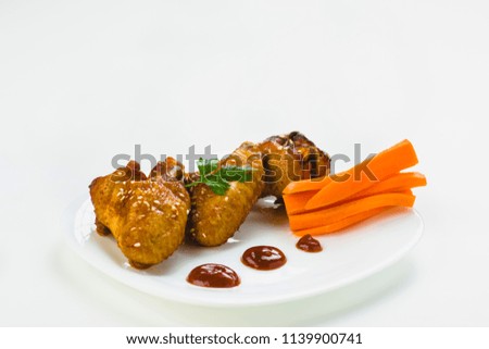 fried chicken wings with sesame on a white plate
