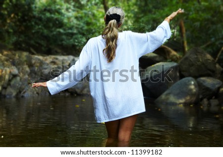 View of young woman trying to walk through the mountain lake