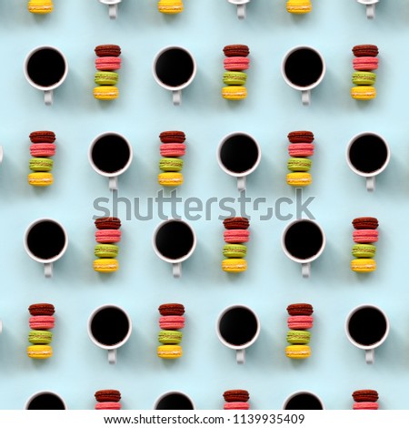 A pattern of many colorful dessert cake macaroon and coffee cups on trendy pastel blue background top view. Flat lay composition