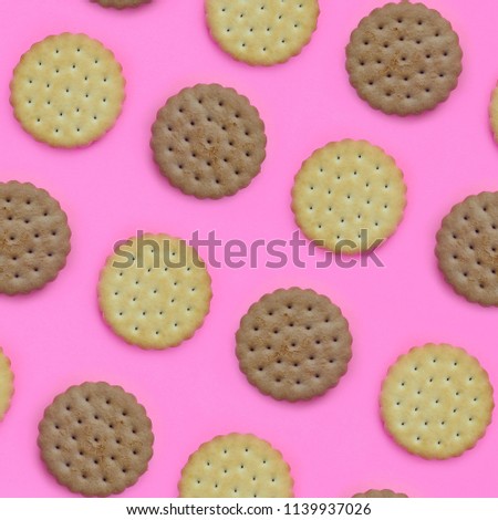 Pattern of a brown biscuits on a pink background. Trendy minimal concept of food and dessert. Abstract flat lay, top view