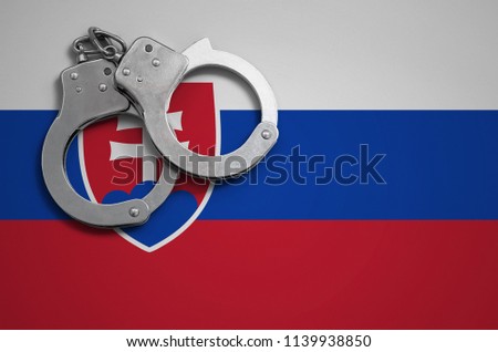 Slovakia flag  and police handcuffs. The concept of crime and offenses in the country