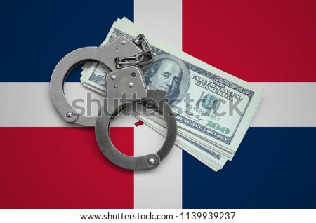 Dominican Republic flag  with handcuffs and a bundle of dollars. Currency corruption in the country. Financial crimes
