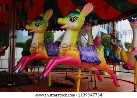 Carousel is an amusement ride on a rotating platform with seats for riders.