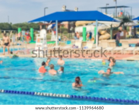 Blurred children and their parents enjoy swimming and water activities at community outdoor swimming pool. Healthy lifestyle, active parent, swim lesson activity, family vacation at aquatic center Royalty-Free Stock Photo #1139964680
