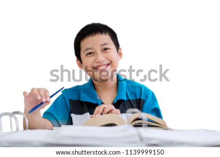 Picture of little boy smiling at the camera while taking notes in the studio, isolated on white background