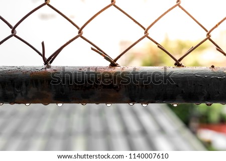 Water droplets on old steel grilles with warm light on background blurred