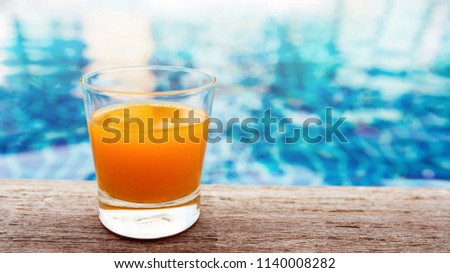 Summer Drink at the Swimming Pool. Glass of Orange Juice on the Poolside. Relaxation on Vacation or Holidays Concept