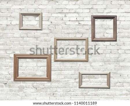 old photo frames on brick wall