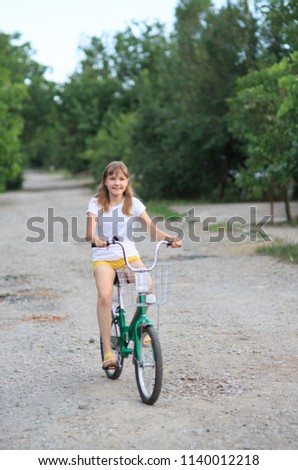 A teenage girl with a bike-riding in the street