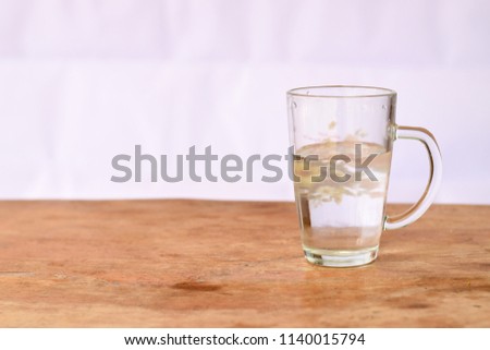Glass of water on a wooden table white background