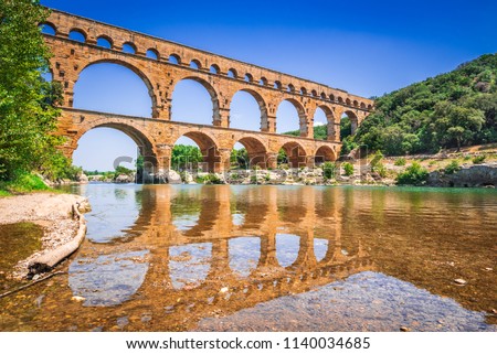 Pont du Gard three-tiered aqueduct was built in Roman times on the river Gardon. Provence summer day. Royalty-Free Stock Photo #1140034685