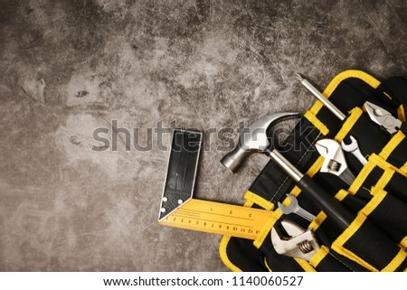 Construction worker belt with tools on concrete texture background. Free space for text
