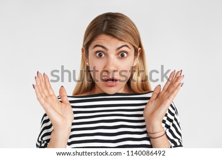 Human emotions, feelings and reaction. Picture of stylish funny girl gesturing emotionally and popping eyes out, can't believe unexpected astonishing news. Blonde female showing surprised reaction