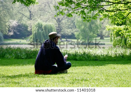 young man using a cellphone while resting in park Royalty-Free Stock Photo #11401018