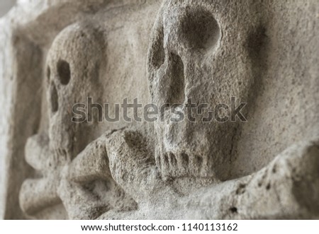 Ancient stone skull with crossbones. Old sculpture. Ideal for concepts and backgrounds.