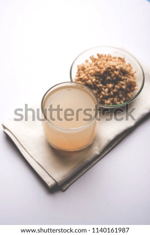 Barley water in glass with raw and cooked pearl barley wheat/seeds. selective focus
