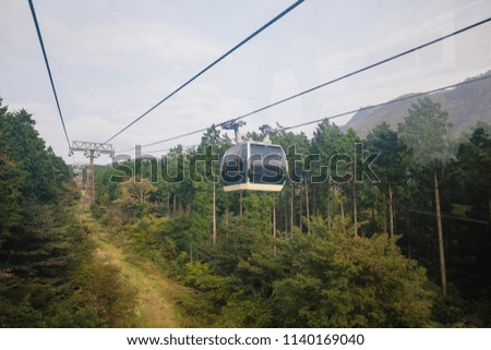 Ropeway cable car travelling with mountain and sky in Owakudani at Hakone.