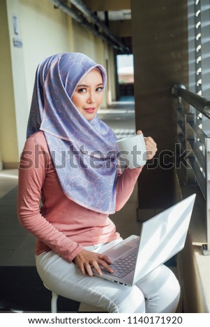 Young Muslim Girl Working on Laptop on Desk