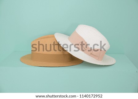 Two pretty straw hat isolated on light blue background,

